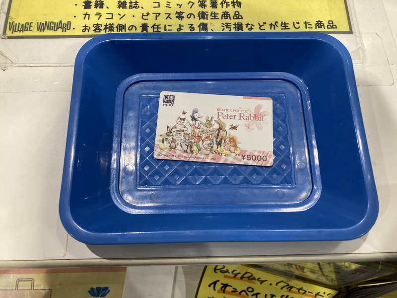 ヴィレッジヴァンガードのレジで図書カードを使ってムック本を買う様子
